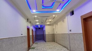 A hallway with patterned flooring, recessed lighting, and a ceiling fan. - The Nirmala palace (Faizabad)