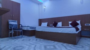 A bedroom with a bed, a desk, and a chair. - The Nirmala palace (Faizabad)
