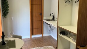 Uma cozinha compacta com pia embutida, porta de madeira e bancada pequena.