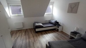A small, modern bedroom with a loft bed, a bedside table, and a radiator. - Monteurzimmer mit Fast Wlan, Einzelbetten, Smart TV je Zimmer, Osnabrück (Osnabrück)