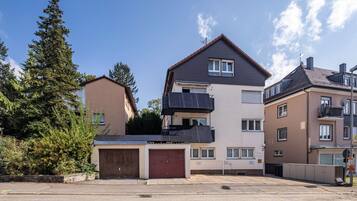 Ein mehrstöckiges Wohnhaus mit Garage, Balkon und Satellitenschüssel.