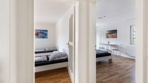 A room with a bed, a desk, and a chair, with a view of the outdoors. - Apartment 'Wohnung 03' with Balcony and Wi-Fi (Waiblingen)