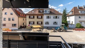 A construction site with a blue tractor, piles of sand, and construction barriers. - Apartment 'Wohnung 03' with Balcony and Wi-Fi (Waiblingen)