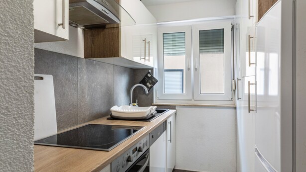 A compact kitchen with a stove, oven, sink, and a refrigerator. - Apartment 'Wohnung 03' with Balcony and Wi-Fi (Waiblingen)