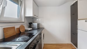 A compact kitchen with a microwave, oven, and built-in dishwasher. - Apartment 'Wohnung 06' with Wi-Fi (Waiblingen)