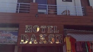 Un edificio de varios pisos con un cartel que dice "HOTEL DAKSH" en la planta baja.