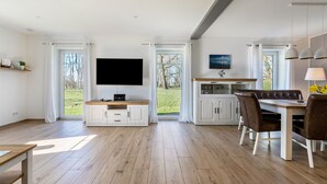 Una cocina moderna con comedor, ventanas amplias y un televisor de pantalla plana.
