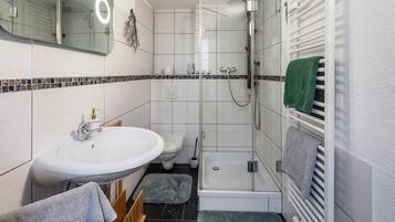 Kylpyhuone, jossa on pesuallas, wc, suihku ja pyyheteline.