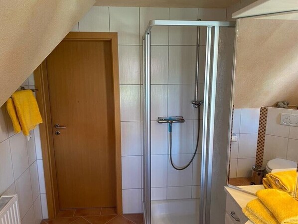 A bathroom with a shower, a toilet, and a sink.