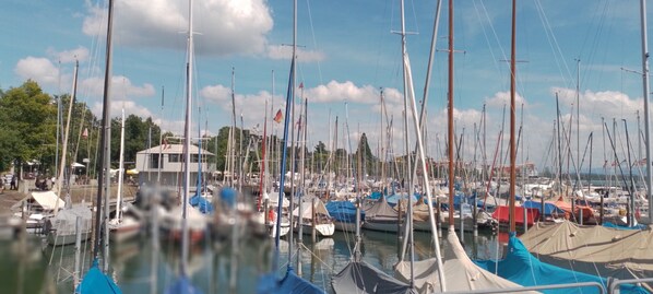 Ein Yachthafen mit zahlreichen vertäuten Booten, ein Gebäude mit flachem Dach und ein klarer Himmel.