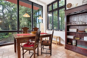 Un coin repas avec une table en bois, des chaises et une bibliothèque.