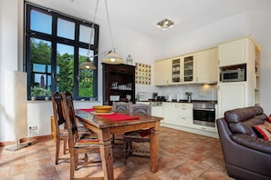 Une cuisine avec une table  à manger, des chaises et un canapé.