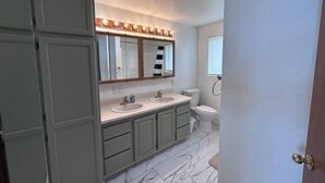 Ein Badezimmer mit zwei Waschbecken, einer Toilette und einer Dusche.
