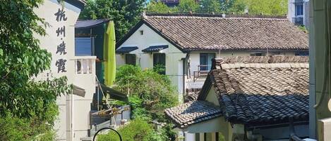 A traditional Chinese courtyard with a pagoda in the background, surrounded by buildings with tiled roofs and greenery.