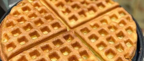 A waffle iron with a waffle inside.