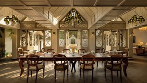 A dining area with a long table, multiple chairs, and a chandelier. - Uga Halloowella - Hatton - All Inclusive (Norwood)