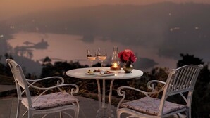 A table set for two with chairs, a candle, and a vase with flowers. - Uga Halloowella - Hatton - All Inclusive (Norwood)