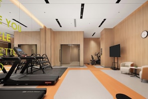 A modern gym with treadmills, dumbbells, and a stationary bike.