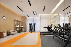 A modern gym with exercise equipment, a wall clock, and a motivational message. - Home2 Suites BY Hilton Kunming Xishan (KUNMING)