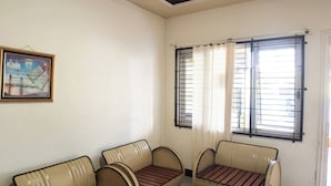 Une pièce avec deux canapés de couleur beige, une table en verre et un certificat encadré accroché au mur.