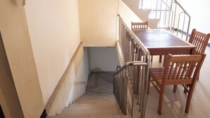 Un escalier avec une table et des chaises en bois, menant à un palier.