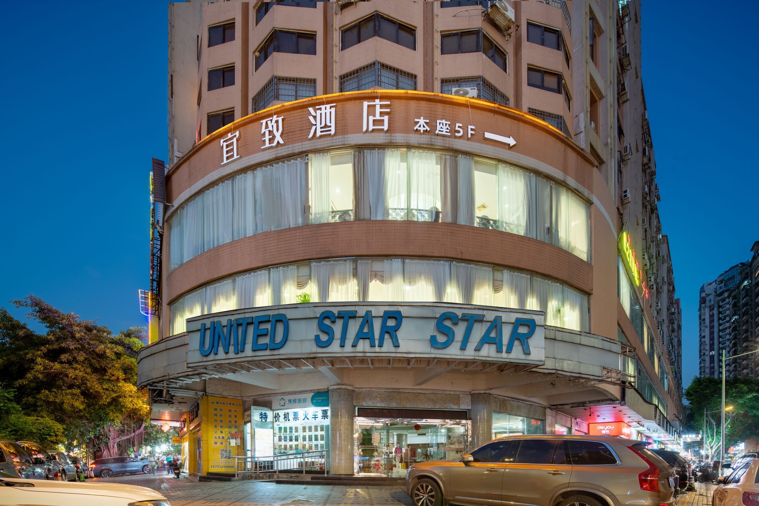 A hotel with a prominent "UNITED STAR STAR" sign, multiple floors, and a modern architectural design.