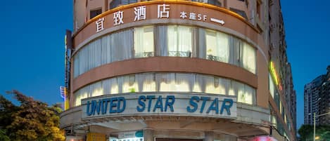 A hotel with a prominent "UNITED STAR STAR" sign, multiple floors, and a modern architectural design.
