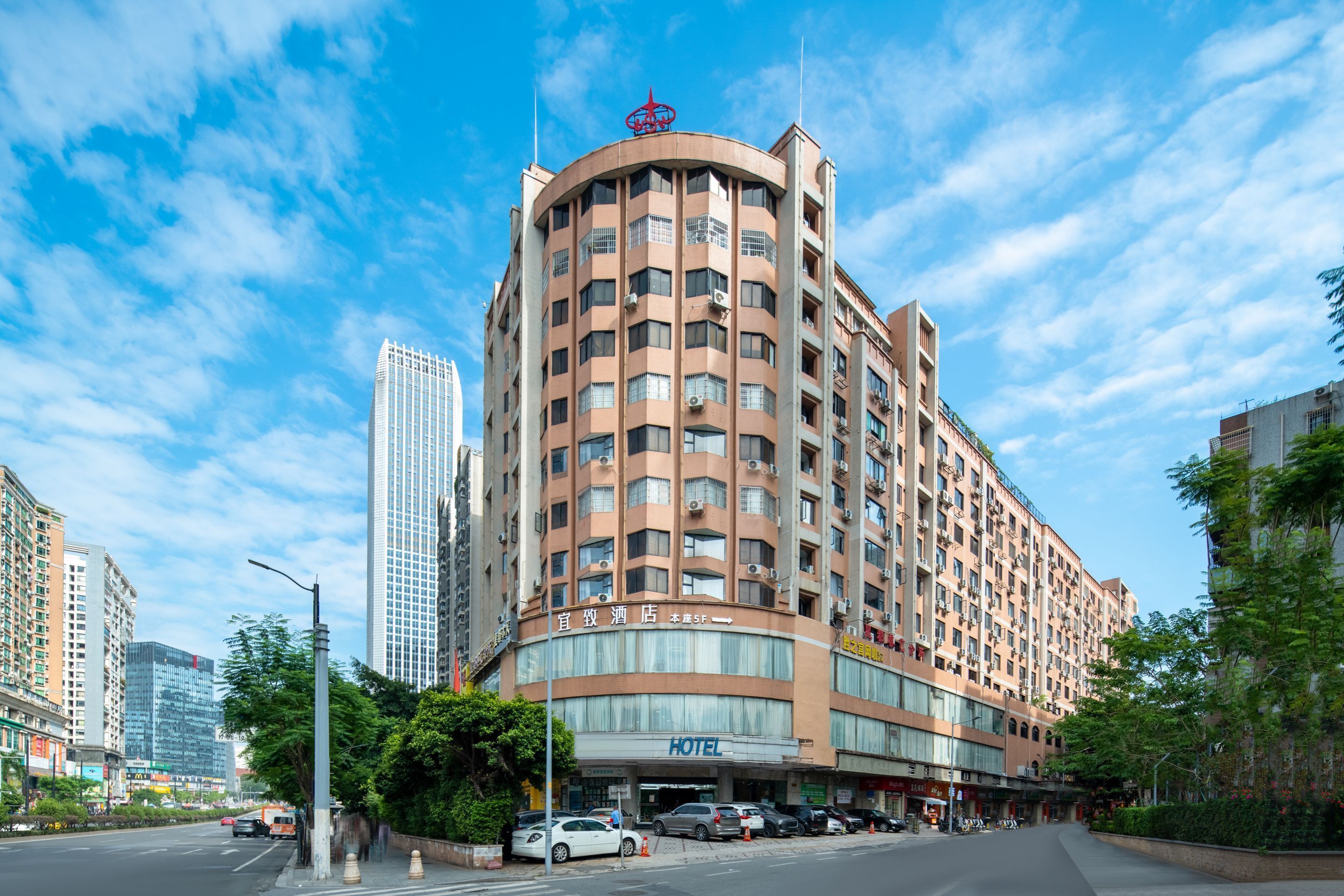 A multi-story hotel with a curved facade, large windows, and a prominent hotel sign.