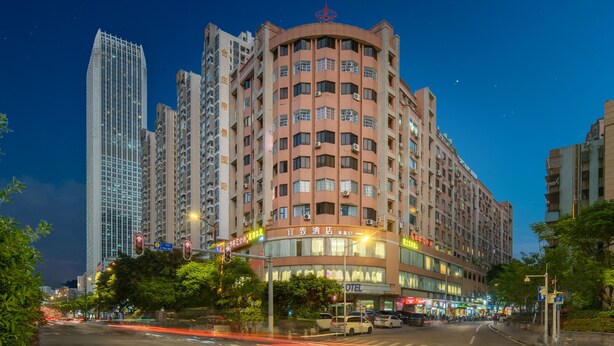 Un hotel con fachada moderna, varios pisos y señalización llamativa.