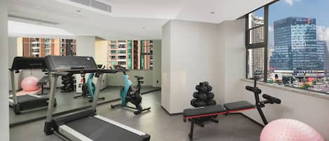 A modern gym with treadmills, an exercise bike, and a rowing machine.