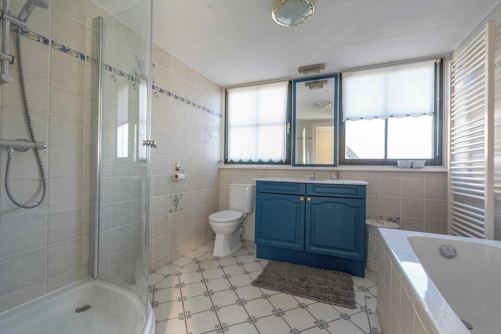 Een badkamer met een douche, toilet, wastafel en bad.