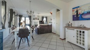 Un'ampia zona giorno con tavolo da pranzo, divano e un quadro appeso al muro.