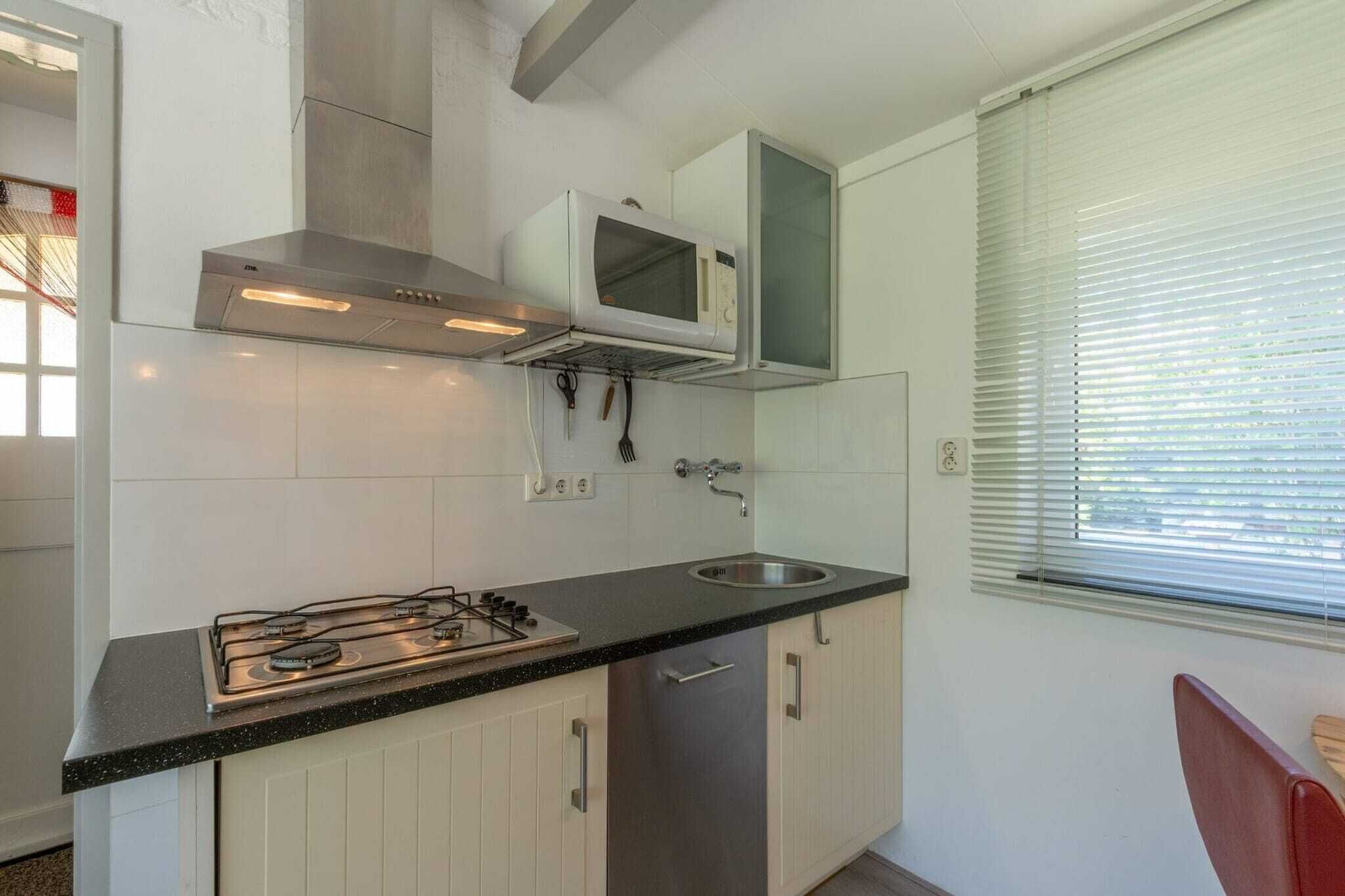 A compact kitchen with a gas stove, a microwave, and a sink.