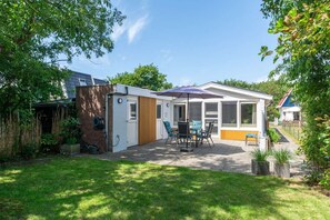 A modern house with a patio, a dining area, and a covered outdoor space. - Garnekuul 49 holiday home in Callanstoog (Callantsoog)