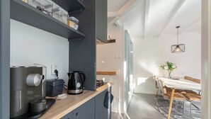 Una cocina moderna con cafetera, hervidor y recipientes de almacenamiento en la encimera.