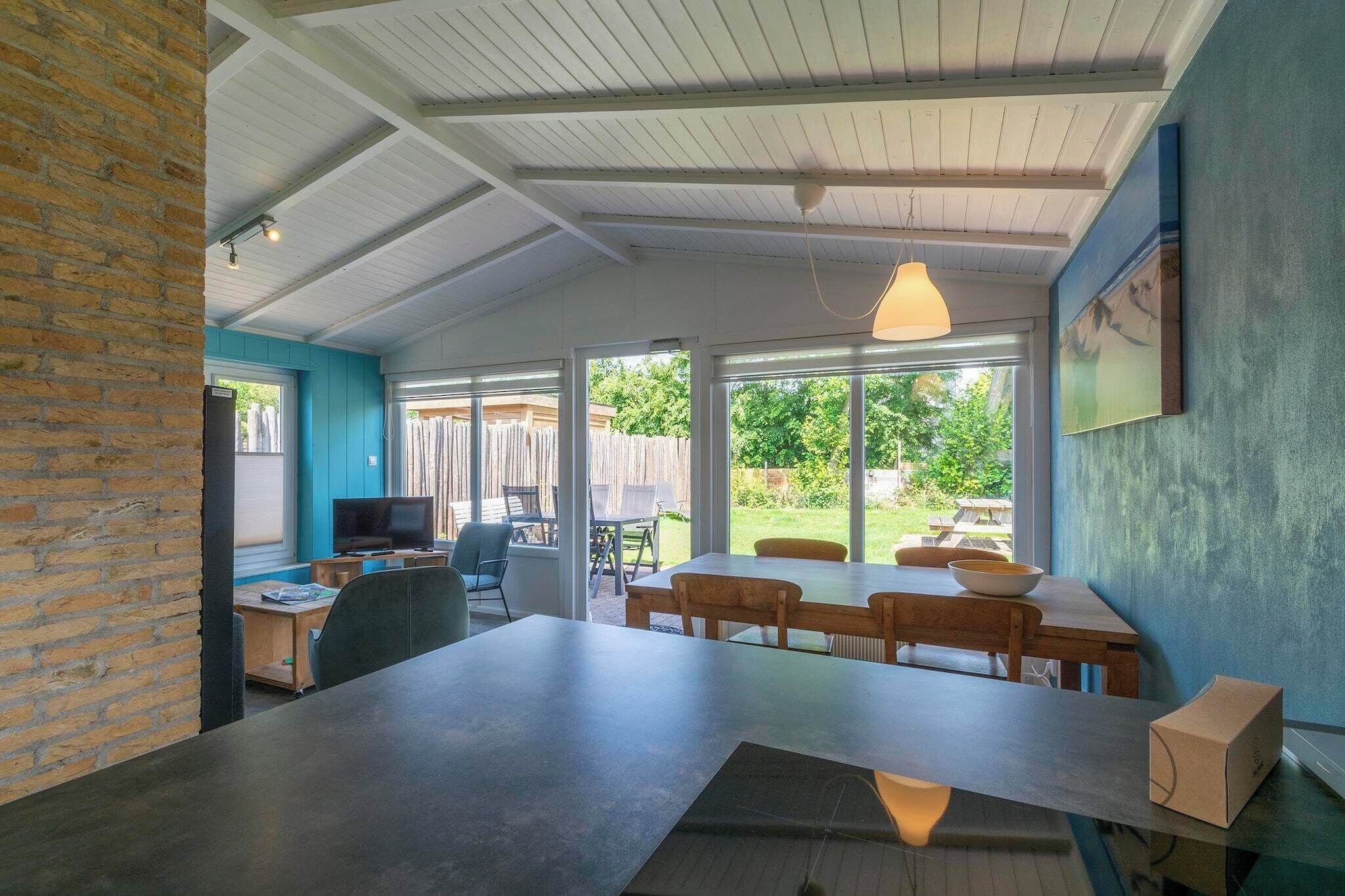 A modern kitchen with a large island, white cabinets, and a view of the backyard.