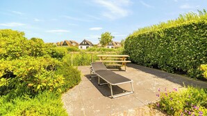 A garden area with a picnic table and a bench, surrounded by greenery and houses in the background. - Villa with view over the park De Buitenplaats (Callantsoog)