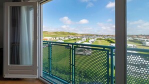 A balcony with a view of a caravan park and green hills. - Cozy Stay Near Dunes (Julianadorp aan Zee)