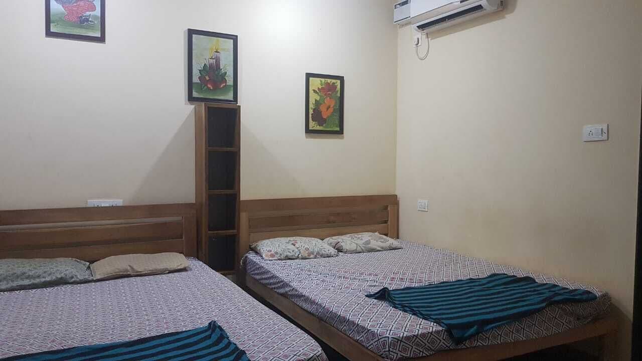 A room with two beds, a wooden headboard, and a ladder.