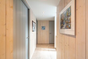 A hallway with wooden walls, a framed picture, and a sign.