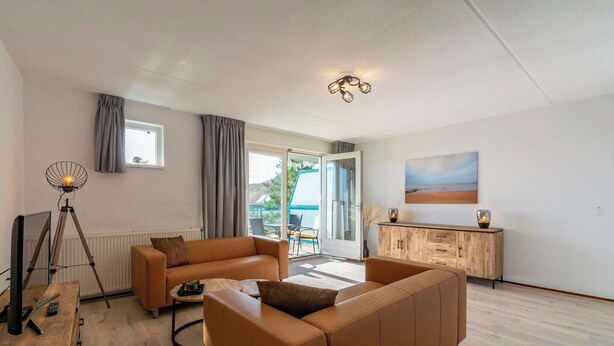 A modern living room with a sofa, a coffee table, a lamp, and a cabinet.