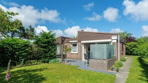 A modern two-story house with a brick exterior, a covered porch, and a well-maintained lawn. - Bungalow near Beach and Forest in De Blenck (Callantsoog)