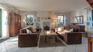 A cozy living room with two brown sofas, a wooden coffee table, and a fireplace. - De Buitenplaats 145 villa with sauna (Callantsoog)