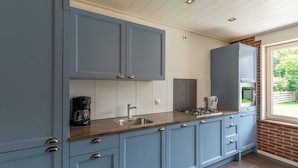 Una cocina moderna con alacenas azul claro, encimera de madera y horno empotrado.