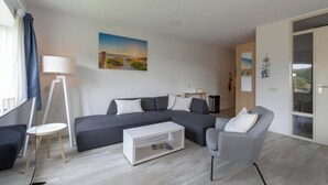 A modern living room with a sectional sofa, a coffee table, and a grey armchair.