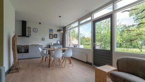 A modern kitchen with a dining area, large windows, and a view of the outdoors. - De Zeester 4-person holiday home n De Koog (Callantsoog)