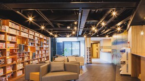 A modern library with bookshelves, a sofa, and a reception desk. - Giappo Franca Kyoto (Kyoto)