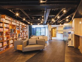 Una biblioteca moderna con estanterías, un sofá y un mostrador de recepción.