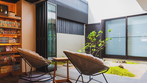 A modern interior with a bookshelf, two rocking chairs, and a small table. - Giappo Franca Kyoto (Kyoto)