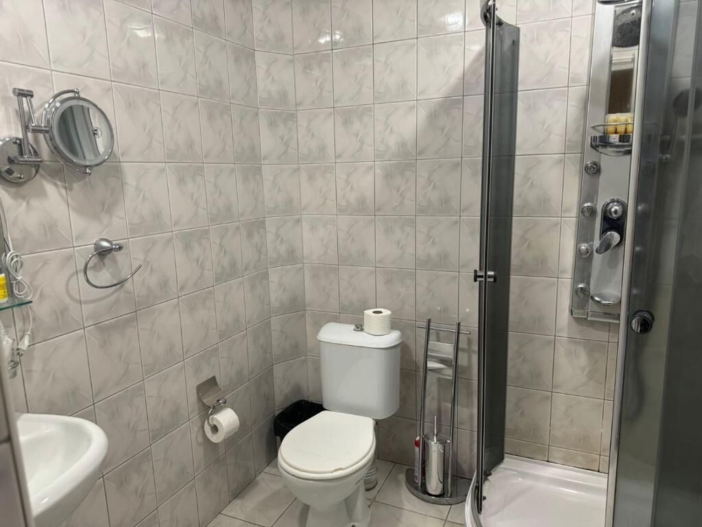 Un baño pequeño con inodoro, lavamanos y ducha.